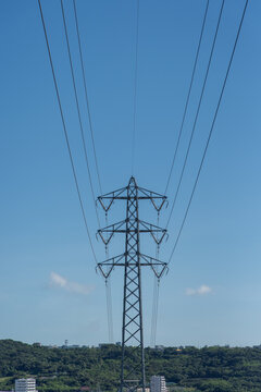 快晴の空で前後に伸びる送電線と送電鉄塔