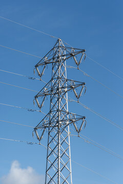 快晴の空で左右に伸びる送電線と送電鉄塔