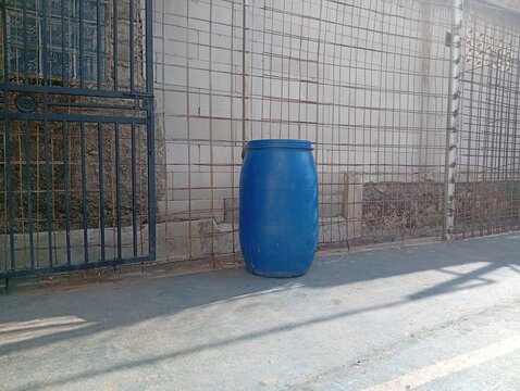 Blue Chemical Storage Drum Outdoors in Educational Facility Area