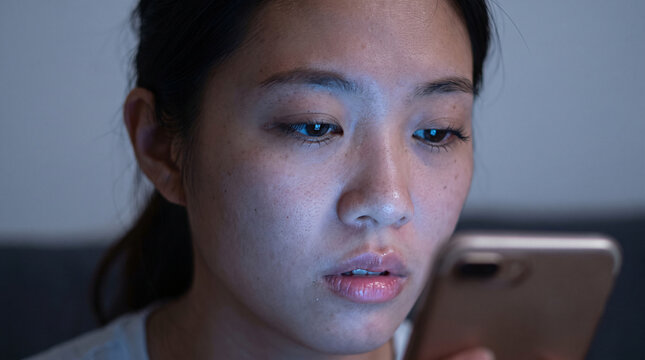 Tired Woman Checking Time and Scrolling Phone

