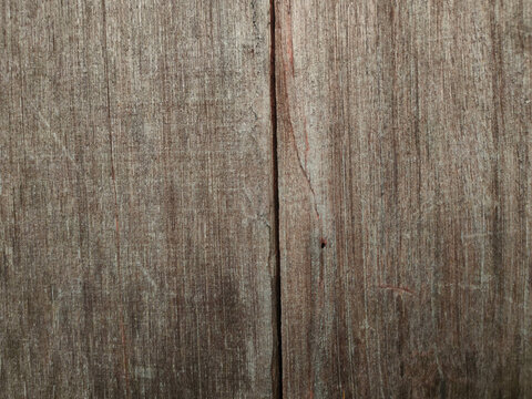 A close-up view of two vertical wooden planks split by a prominent dark central gap showing fine grain lines