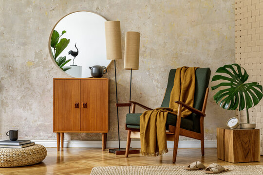 Modern retro composition of living room interior with design armchair, pouf, tea pot on the tray, plant, plaid, carpet, decoration and elegant presonal accessories in wabi sabi concept.