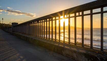 Obraz premium Sunset View Over Ocean Behind Fence on Coastal Path