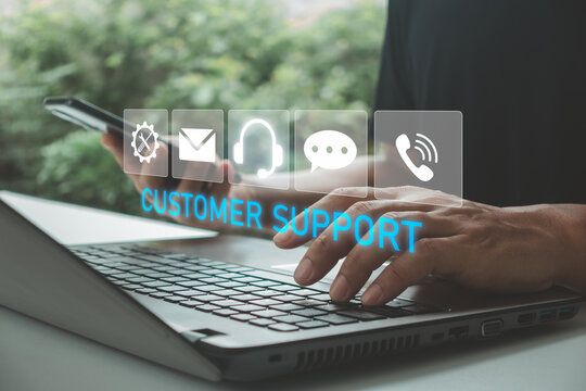 Businessman using laptop and smartphone with virtual customer support interface, representing online service, help desk, live chat, contact center, technical assistance and digital communication.