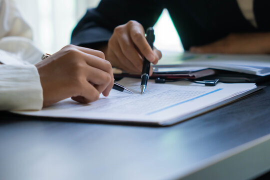 Asian businesswoman using pen pointing at document