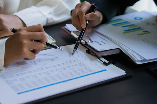 Asian businesswoman using pen pointing at document