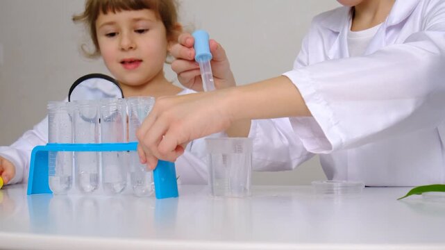 Laboratory examination of a child with test tubes, reagents and a microscope. Selective focus.