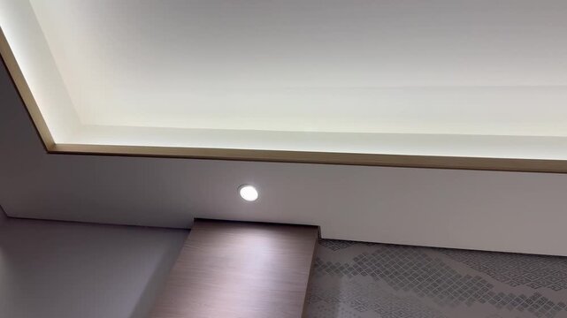 Clean minimalist interior ceiling corner featuring a recessed spotlight, ideal for architecture and modern home design concepts