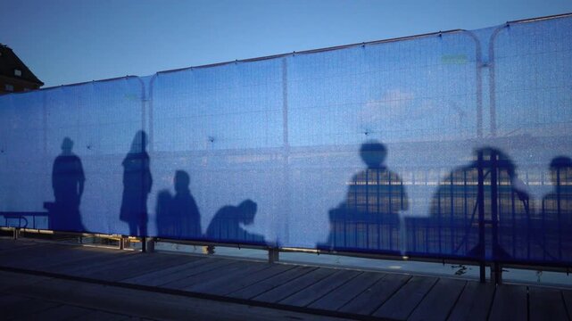 Stockholm, Sweden Shadows of people dancing at sunset projected onto a blue construction screen in the news redeveloped Slussen district. 