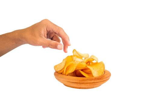 hand gesture reaching for potato chips on a wooden bowl