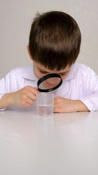 Laboratory examination of a child with test tubes, reagents and a microscope. Selective focus.