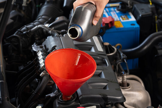 Refueling and pouring oil quality into the engine motor car Transmission and Maintenance Gear .Energy fuel concept.	
