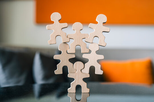 Wooden human figure carrying team burden business leadership stress foundation support heavy responsibility overload pressure burnout corporate concept.