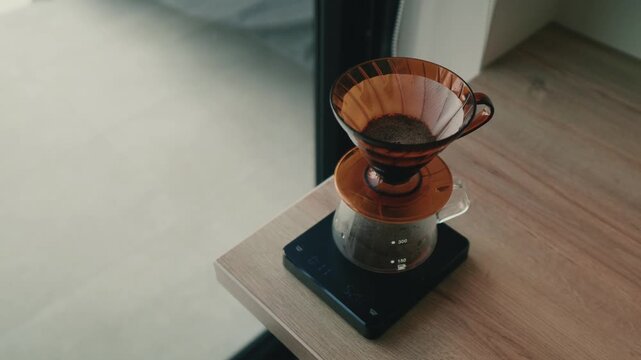 Hands pouring hot water over coffee grounds in a V60 dripper during a pour over coffee brewing process