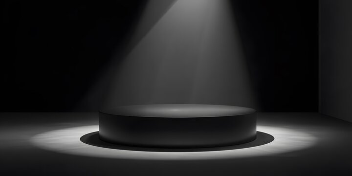 Spotlight illuminates a dark stage with a circular platform.