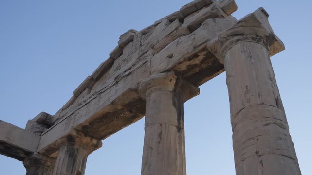 Panning shot of the ancient roman agora ruins, a famous landmark of Athens, Greece, against blue sky. Tilt up Shot