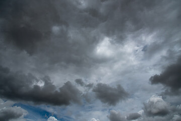 Obraz premium Dark thunderstorm clouds rainny season. Meteorology danger windstorm disasters climate. Banner Dramatic dark storm clouds black sky background. Dark thunderstorm clouds rainny atmosphere.