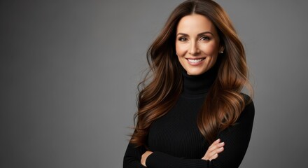 Fototapeta premium Confident Professional Woman with Long Brown Hair Smiling in Black Turtleneck Against Gray Background