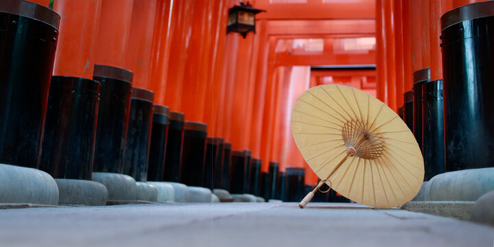 Traditional Japanese Paper Umbrella on Ground Inside Red Torii Gate Tunnel at Fushimi Inari Kyoto