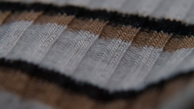 Stock-Ready Abstract Texture Background: Grey-Brown-Black Ribbed Fabric Surface with Soft Focus Gradient for Ample Copy Space