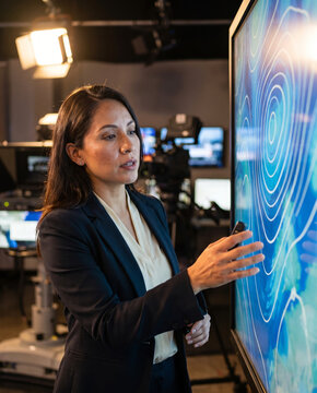Female meteorologist presenting weather forecast in television studio