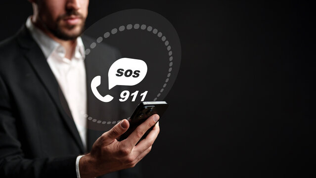 Person holding smartphone with 911 emergency call and SOS message displayed on screen in dark setting