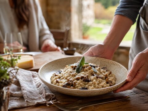 Risotto con setas servido en mesa en un entorno r&uacute;stico en Italia