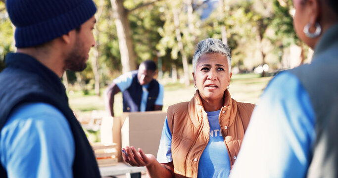 Volunteer, woman and conversation in park with team, manager instructions or outreach for non profit. People, discussion and charity project outdoor with social responsibility, planning or NGO group.
