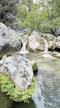 The river's cascading waterfalls, the coolness of the water, the summery atmosphere, and the relaxing environment.