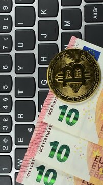 Bit Coins and Euro money on computer Keyboard vertical view