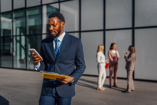 Worried businessman checking smartphone for important updates