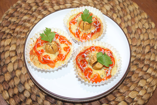 Delicious Mini Sausage Pizza Muffins with Chili Sauce Drizzle