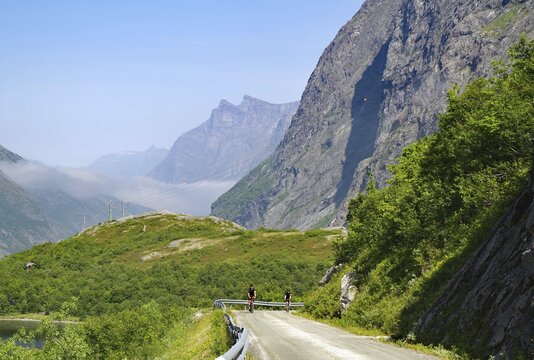 Cyclists on a mountainous, spectacular road surrounded by green nature, Eikesdalen, Eikesdalvatnet, Aursj&ouml;vegen, More og Romsdal, Norway