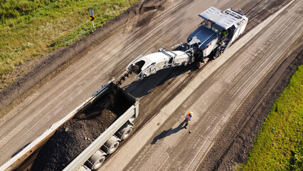 Aerial Shot of Cold Recycler Loading Milled Asphalt into Dump Truck © Andrey