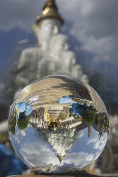 The five seated Buddhas (path to enlightenment) are reflected in a glass sphere, Wat Phra That Sorn Kaew Buddhist temple complex, Phetchabun province, Isan, Thailand
