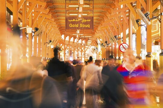 Dubai, UAE - 17th january, 2026: Dubai Gold Souk in Deira. Zoom in timelapse crowds visitors under traditional wooden architecture historic bazaar. Gold industry trade investment background concept