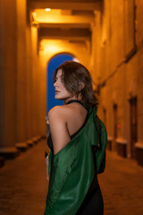 Obraz premium Stylish woman in green leather jacket posing in city night