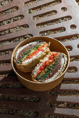 Sushi burger on a metal wire rack. Delivery box. Art photo © Cavan
