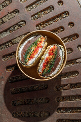 Sushi burger on a metal wire rack. Delivery box. Art photo © Cavan