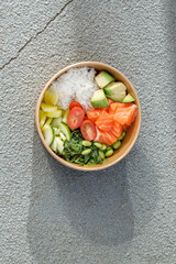 Salmon poke bowl in a delivery box on road markings. Isolated © Cavan