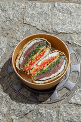 Sushi burger on a metal wire rack. Delivery box. Art photo © Cavan