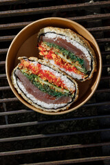 Sushi burger on a metal wire rack. Delivery box. Art photo © Cavan