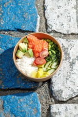 Salmon poke bowl in a delivery box on road markings. Isolated © Cavan