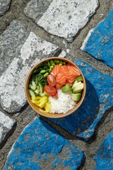 Salmon poke bowl in a delivery box on road markings. Isolated © Cavan