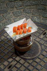 Philadelphia roll with salmon on a metal wire rack. Delivery box © Cavan