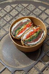 Sushi burger on a metal wire rack. Delivery box. Art photo © Cavan