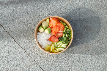 Salmon poke bowl in a delivery box on road markings. Isolated © Cavan