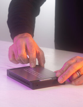 Close Up of Hands Pressing Touch Sensor on Sleek Hardware Device