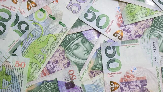 Top view 4K video. 50 GEL bank note, fifty lari bill. Georgian cash money with female face, Queen Tamara portrait. Green paper banknotes of Georgia. Concept of currency exchange, pay tax, debt, loan