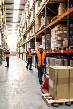 Warehouse team managing inventory and moving goods with pallet jacks, ensuring efficient supply chain operations and freight delivery